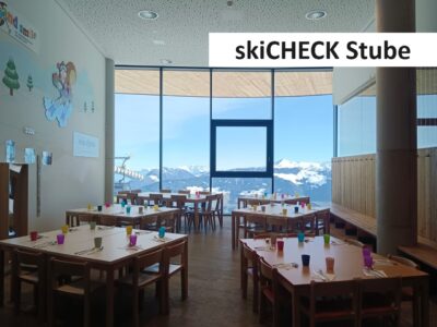 Kinderrestaurant skiCHECK Stube mit bunt gedeckten Tischen und Panoramafenster zu den Bergen