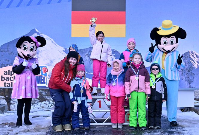 Kinder mit Medaillen auf dem Siegerpodest beim Skirennen im Alpbachtal, daneben zwei Maskottchen
